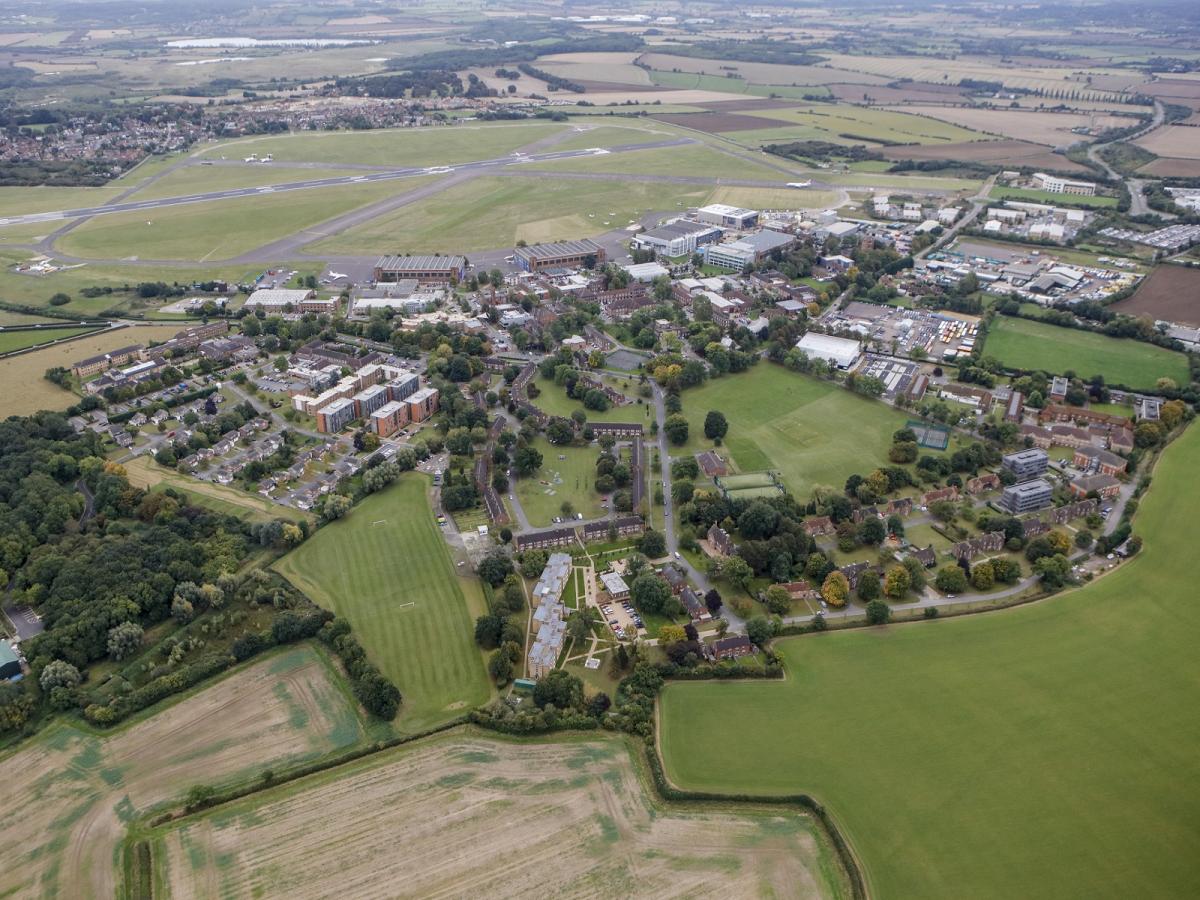 英国克兰菲尔德大学官网校园建筑群与机场跑道航拍照片，仅作院校识别，不代表具体项目授课地点或出境要求。