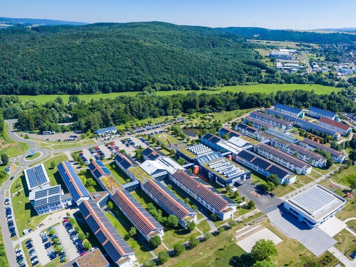 德国特里尔应用技术大学环境校区 Birkenfeld 航拍实景，建筑屋顶设有太阳能板