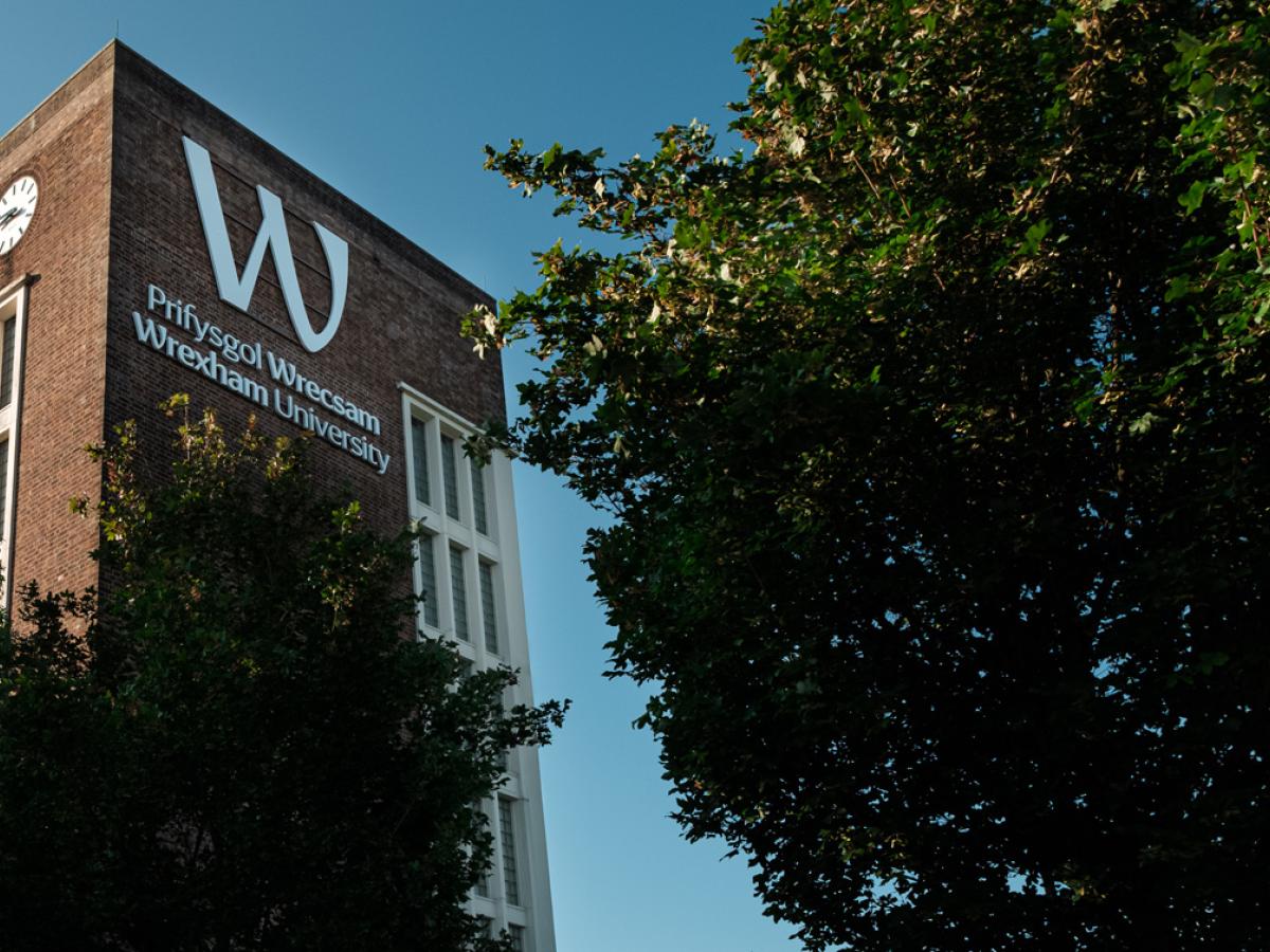 雷克瑟姆大学官网校园钟楼与校名照片，仅作院校识别，不代表相关项目实际授课地点或出境要求。