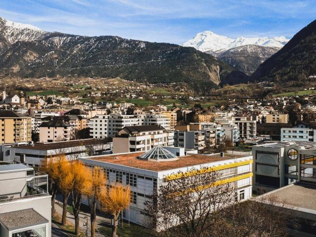 恺撒里兹学院官网Brig校区建筑及周边山景实景，仅作院校识别，不代表具体项目授课地点或出境要求。