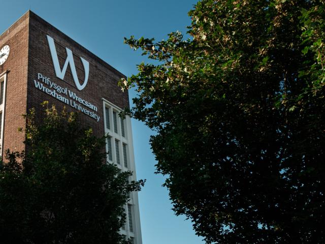 雷克瑟姆大学官网校园钟楼与校名照片，仅作院校识别，不代表相关项目实际授课地点或出境要求。